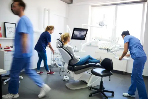 Blurred view of dentists and woman in dentist's Clinic
